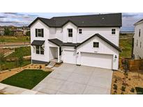 Charming two-story home with a modern design, white siding, dark trim and a spacious three car garage and concrete driveway at 9382 Quaker St, Arvada, CO 80007