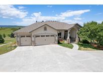 Beautiful home featuring an attached three-car garage and a meticulously maintained lawn at 4002 Bell Mountain Dr, Castle Rock, CO 80104