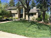 Charming home with a well-manicured lawn, mature trees, and beautiful landscaping at 10291 E Powers Ave, Greenwood Village, CO 80111