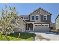 Charming two-story home featuring a stone accents, attached two-car garage and landscaped yard at 4600 Thistle Dr, Brighton, CO 80601
