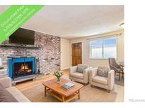 Inviting living room featuring a brick fireplace with a blue firebox and light hardwood flooring at 155 S Pennsylvania St # 311, Denver, CO 80209