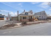 Charming bungalow with a welcoming front porch and landscaped garden beds, complemented by a detached garage at 3420 Julian St, Denver, CO 80211