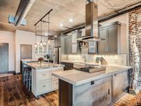 Modern kitchen with stainless steel appliances, pendant lights and exposed ductwork in a loft style apartment at 1401 Wewatta St # 308, Denver, CO 80202