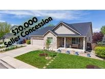 Charming brick home featuring a covered front porch, manicured lawn, and a two-car garage at 14833 Vine St, Thornton, CO 80602