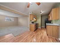 Bright kitchen with wood cabinets, black appliances, granite countertops, and modern flooring at 16259 W 10Th Ave # J1, Golden, CO 80401