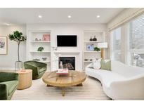 Bright living room featuring a fireplace with built-in shelves and stylish, neutral decor at 3221 Perry St, Denver, CO 80212