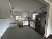 This kitchen features new stainless steel appliances, light countertops and white cabinets at 7691 Osage St, Denver, CO 80221