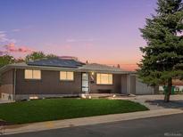 Charming brick home with a well-manicured lawn and modern solar panels at dusk at 8641 Rutgers St, Westminster, CO 80031
