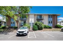 Charming condo building featuring balconies, lush greenery, designated parking, and a welcoming entrance at 12172 Melody Dr # 102, Denver, CO 80234