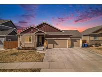 Charming home boasts a three-car garage, stone accents, and neutral siding under a twilight sky at 6817 Sequoia St, Frederick, CO 80530