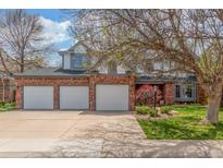 Charming two-story brick home featuring a three-car garage, manicured lawn, and mature landscaping at 16222 E Prentice Ln, Centennial, CO 80015