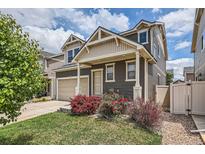 Charming two-story home featuring neutral siding, a two-car garage, and beautifully landscaped front yard at 4414 Walden St, Denver, CO 80249