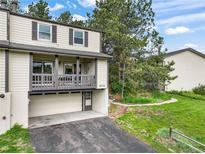 Inviting townhome with a covered porch, garage, and well-maintained landscaping at 404 Raspberry Ln, Monument, CO 80132