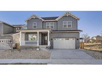 Charming two-story home with a covered front porch and attached two-car garage at 2670 E 102Nd Pl, Thornton, CO 80229