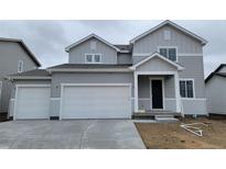 Charming two-story home showcasing a three-car garage, neutral siding, and a welcoming covered entry at 14400 Heritage Dr, Mead, CO 80504