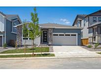 Charming single-Gathering home with a two-car garage, stone accents, and fresh landscaping at 9091 Telluride Ct, Commerce City, CO 80022
