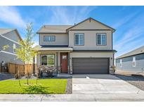 Two-story house with gray siding, brown garage door, and landscaping at 13567 Valentia St, Thornton, CO 80602