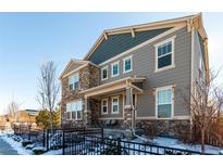 Two-story house with stone and gray siding, showcasing a welcoming front porch at 1126 S Yampa St, Aurora, CO 80017