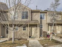 Tan colored townhome with a small front yard and walkway at 11167 W 17Th Ave # 104, Lakewood, CO 80215