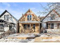 Charming yellow Victorian home with snow-covered front yard at 3737 Jason St, Denver, CO 80211