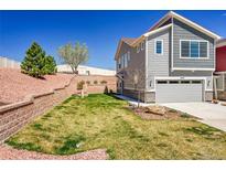 Inviting two-story home featuring a manicured lawn, retaining wall, and attached two-car garage at 4027 E 98Th Pl, Thornton, CO 80229