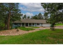 Charming single-story home with well-maintained lawn and welcoming front porch at 1038 Tenderfoot Dr, Larkspur, CO 80118