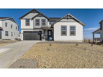 New two-story home featuring a gray and white exterior, attached garage, and rock landscaping at 907 Congress Pl, Elizabeth, CO 80107