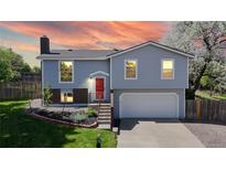 Charming two-story home featuring a red front door, well-manicured lawn, and blooming trees creating curb appeal at 10950 Tennyson Ct, Westminster, CO 80031