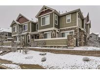 Attractive two-story townhome with stone accents and snow-covered landscaping at 23545 E Platte Dr # C, Aurora, CO 80016