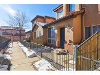 Townhouse exterior with walkway, snow, and fenced entry at 4452 S Auckland Ct, Aurora, CO 80015