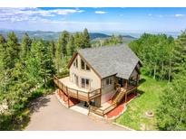 Beautiful exterior with large deck and stunning mountain views and a well-maintained landscaped yard at 10436 Jeanette Ct, Morrison, CO 80465