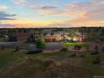 Stunning home with an attached garage, a barn, and a circular driveway on a large lot surrounded by green lawns at 11624 Dunrich Rd, Parker, CO 80138