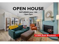 Cozy living room featuring a brick fireplace, comfortable seating, and view of the kitchen area at 8378 S Upham Way # B305, Littleton, CO 80128