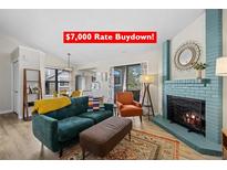 Bright living room featuring a fireplace, comfortable seating, a view of the kitchen area at 8378 S Upham Way # B305, Littleton, CO 80128