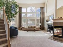 Bright, spacious living room with a large window, fireplace, and comfortable seating arrangement at 7858 Oban Ct, Lone Tree, CO 80124