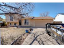 Charming home featuring a well-maintained lawn, classic architecture, and a convenient attached garage at 1123 S Biscay St, Aurora, CO 80017