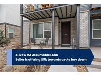 Inviting front porch with seating area, metal roof, and brick accents at 5189 Vivian St, Wheat Ridge, CO 80033