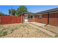 Charming brick home with a well-kept yard and a cozy front porch at 3581 Olive St, Denver, CO 80207