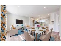 Bright, open-concept living area featuring modern furnishings and a dining space with a sleek marble-top table at 7818 Florado St, Denver, CO 80221