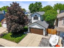 Charming two-story home featuring a well-manicured lawn, a large shade tree, and an attached two-car garage at 3835 Shefield Dr, Broomfield, CO 80020