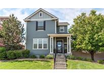 Charming two-story home featuring a covered front porch, landscaped yard, and gray wood siding at 21418 E Stroll Ave, Parker, CO 80138
