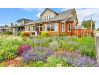 Charming brick home featuring a vibrant and colorful garden in the front yard at 2096 S Logan St, Denver, CO 80210