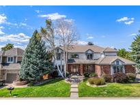 Two-story home with brick and siding exterior, landscaping, and a paved walkway at 5594 S Jasper Way, Centennial, CO 80015