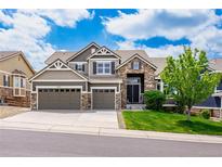 Charming two-story home with a stone and siding exterior, two-car garage, and well-manicured lawn at 5010 Persimmon Ln, Castle Rock, CO 80109