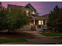 Inviting two-story home with a charming front porch and well-maintained landscaping at 11945 S Saunter Ln, Parker, CO 80138