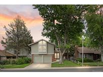 Charming two-story home boasts mature trees, a well-maintained lawn and a two car garage at 12466 E Amherst Cir, Aurora, CO 80014