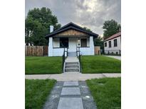 Charming single-Gathering home featuring a manicured front lawn and inviting walkway to the front door at 2541 Elm St, Denver, CO 80207