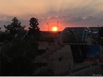 A serene sunset sky over a bridge and lush greenery, creating a beautiful and calming scene at 1438 Little Raven St # 306, Denver, CO 80202