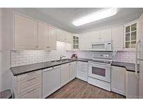 Bright kitchen features stainless steel appliances, white cabinets, and stylish subway tile backsplash at 580 S Clinton St # 11A, Denver, CO 80247