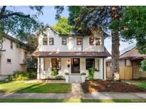 Charming two-story home with a well-manicured lawn and inviting front porch at 1815 S Ogden St, Denver, CO 80210